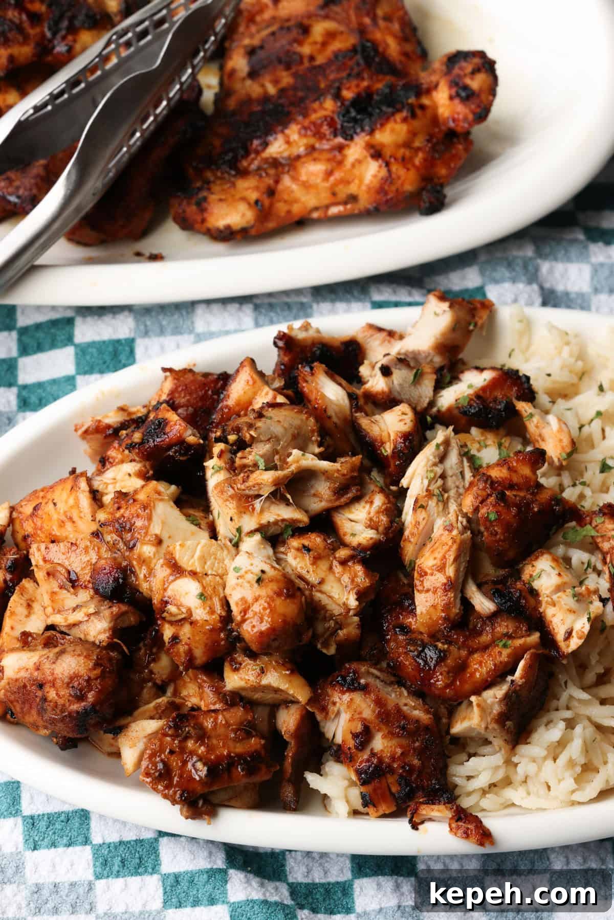 Juicy, smoky copycat Chipotle chicken—perfect for weeknights. Chopped Chipotle chicken served next to rice on a plate, with more chicken on a second plate in the background.