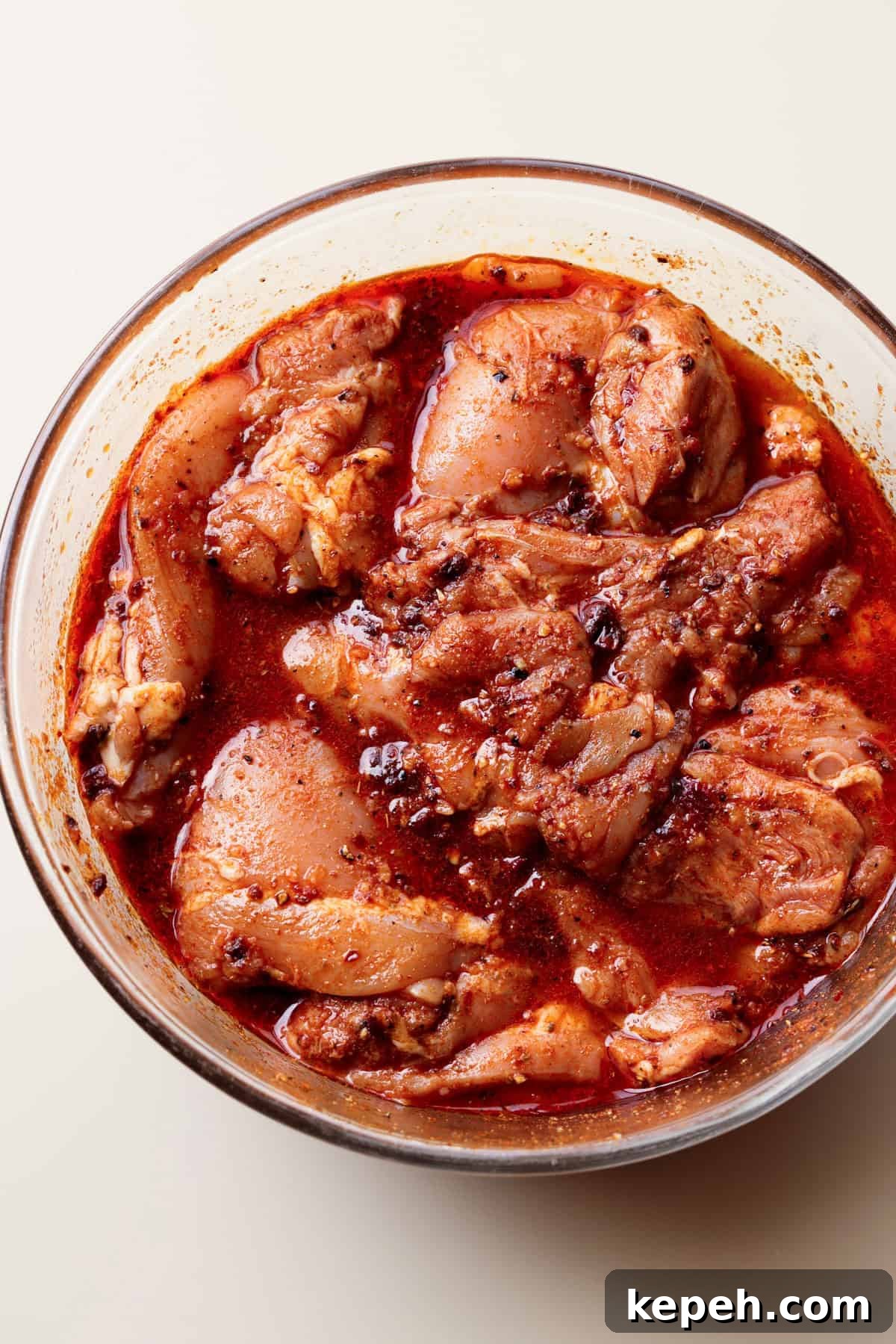 Marinate overnight. Chicken thighs soaked in a bowl of Chipotle marinade.