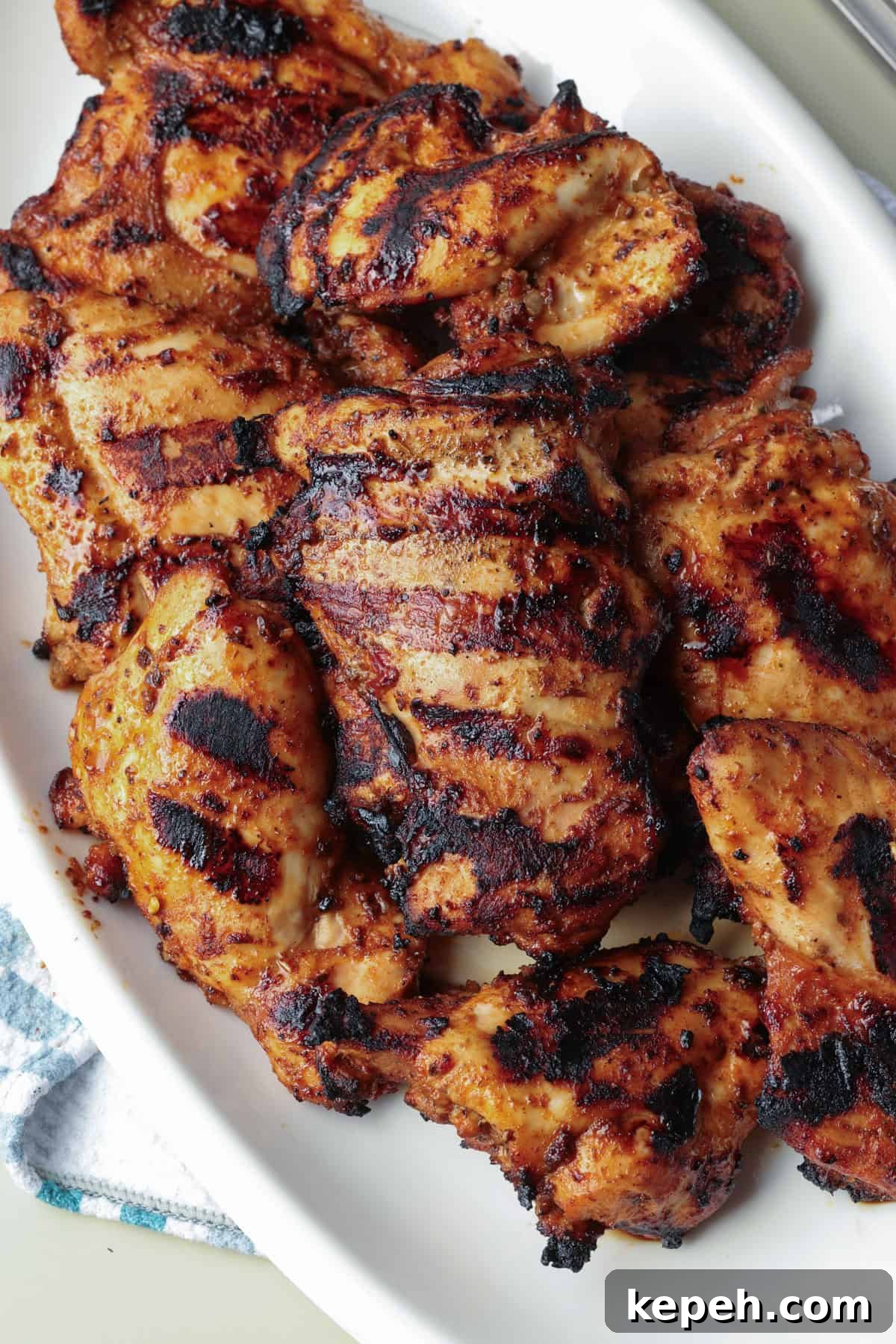 Grilled Chipotle chicken served on a platter. Overhead view of grilled Chipotle chicken thighs on a serving platter.