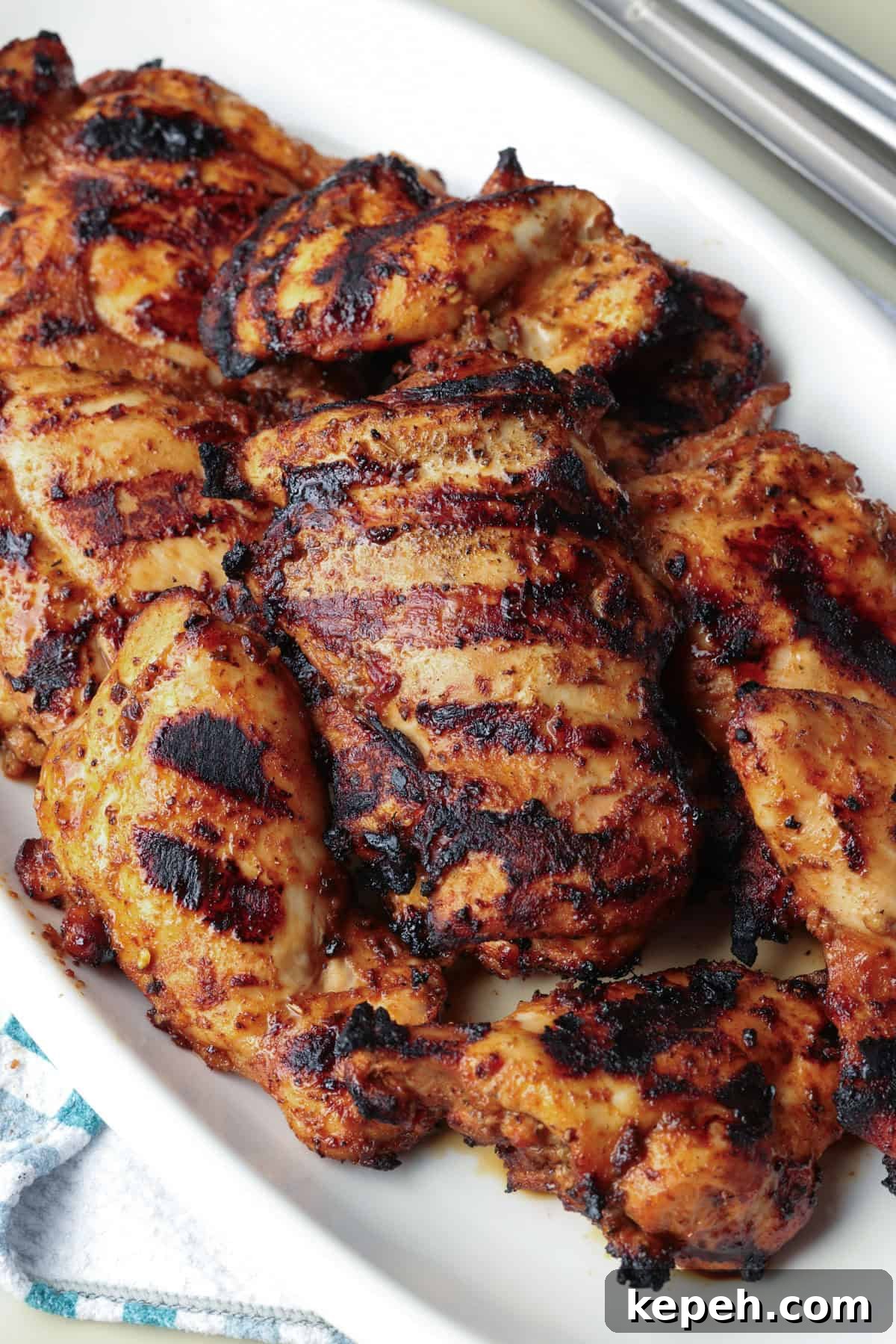 Serve hot or shred for later use. Overhead view of grilled Chipotle chicken thighs on a serving platter.