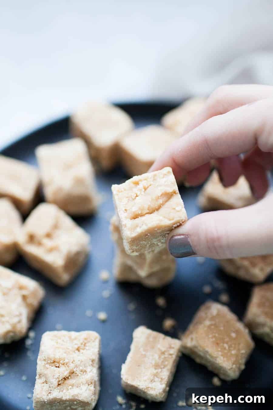 Decadent Peanut Butter Fudge Recipe You'll Love 4 a hand picking up a piece of fudge