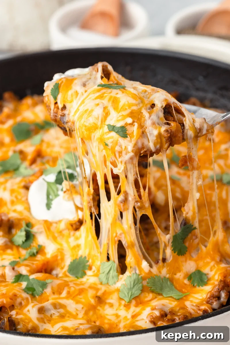 Beef enchilada skillet close up image of scoop of dinner.