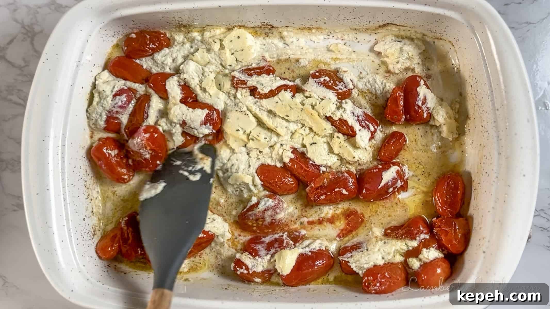 Creamy Boursin Pasta with Garlic and Herbs 6 stirring cheese and tomatoes in a baking dish.