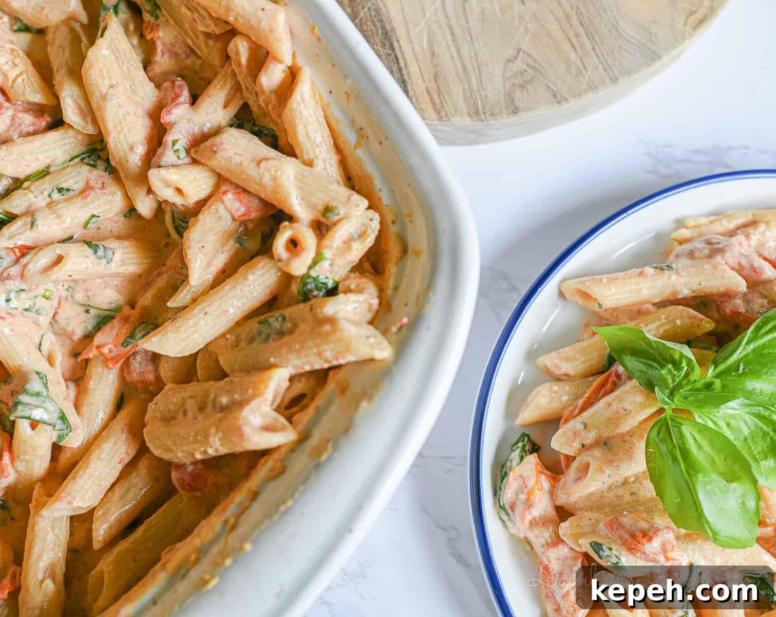 Creamy Boursin Pasta with Garlic and Herbs 8 casserole dish full of boursin cheese pasta next to a serving on a plate.