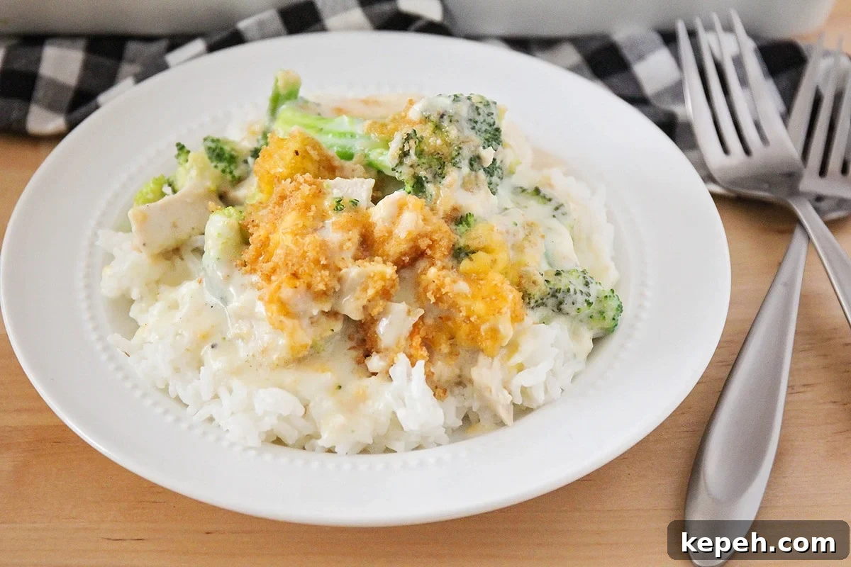 Easy Chicken Divan is loaded with chunks of tender chicken and broccoli and smothered in a cream sauce. It is perfect to freeze for later! Chicken Divan served over rice on a white plate.