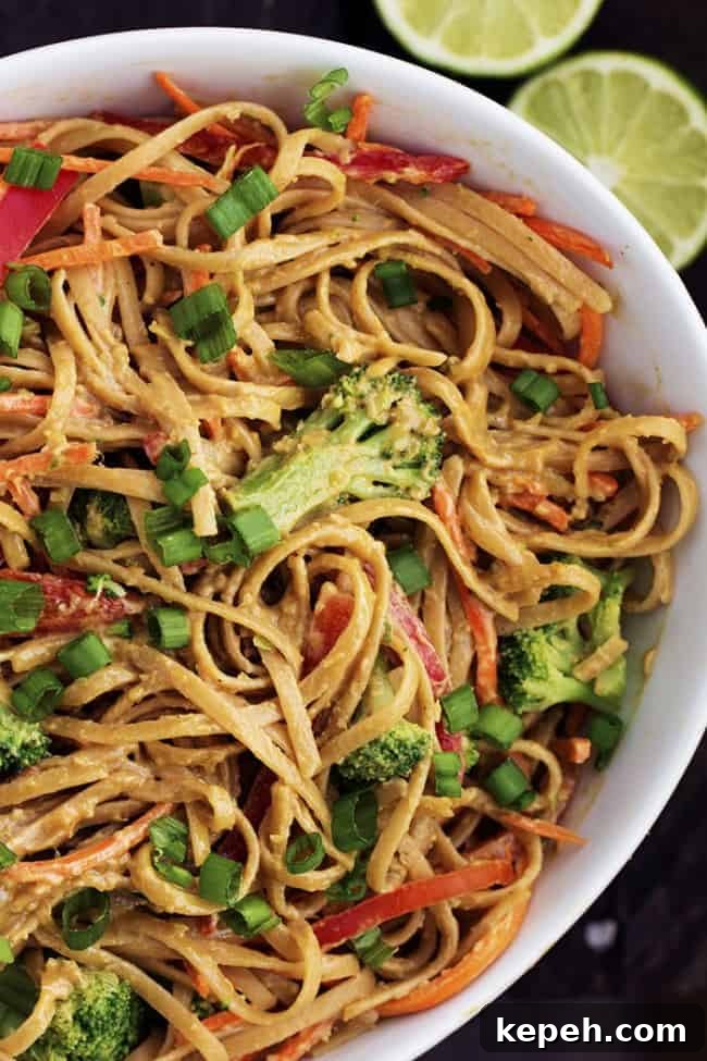 Peanut ginger noodles in a large white bowl.
