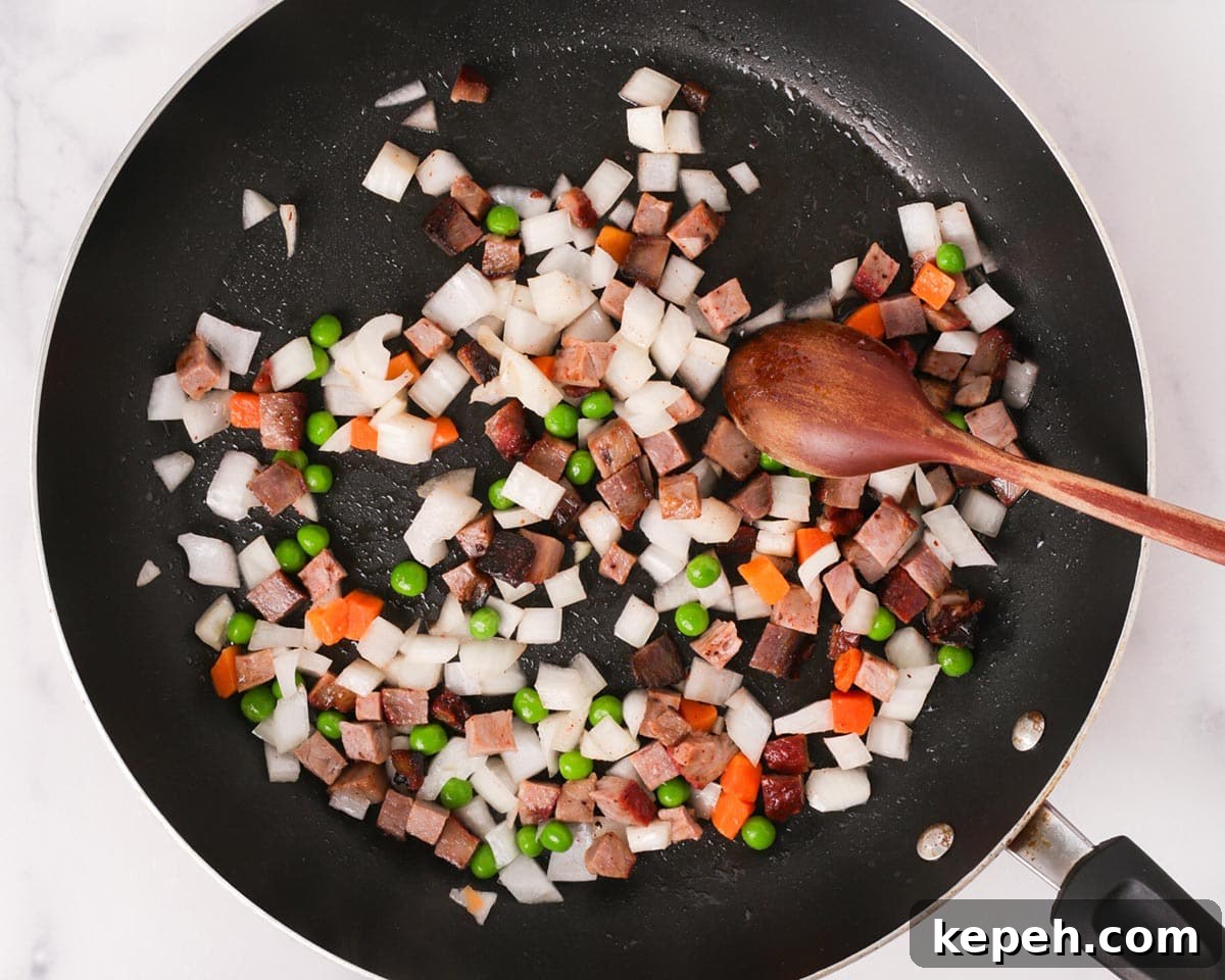 Cooking peas and carrots and diced onions and char siu together.