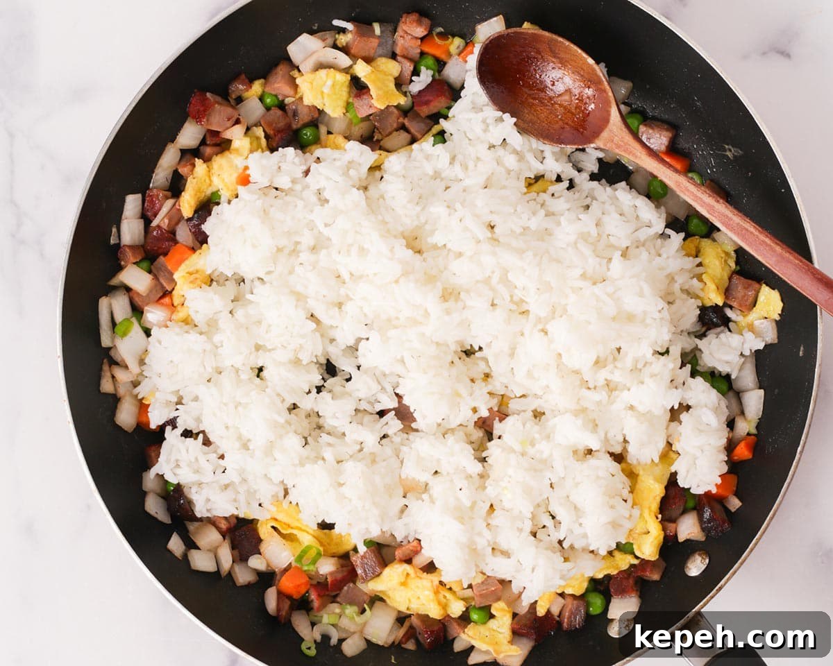 Adding the day old rice to the pan.