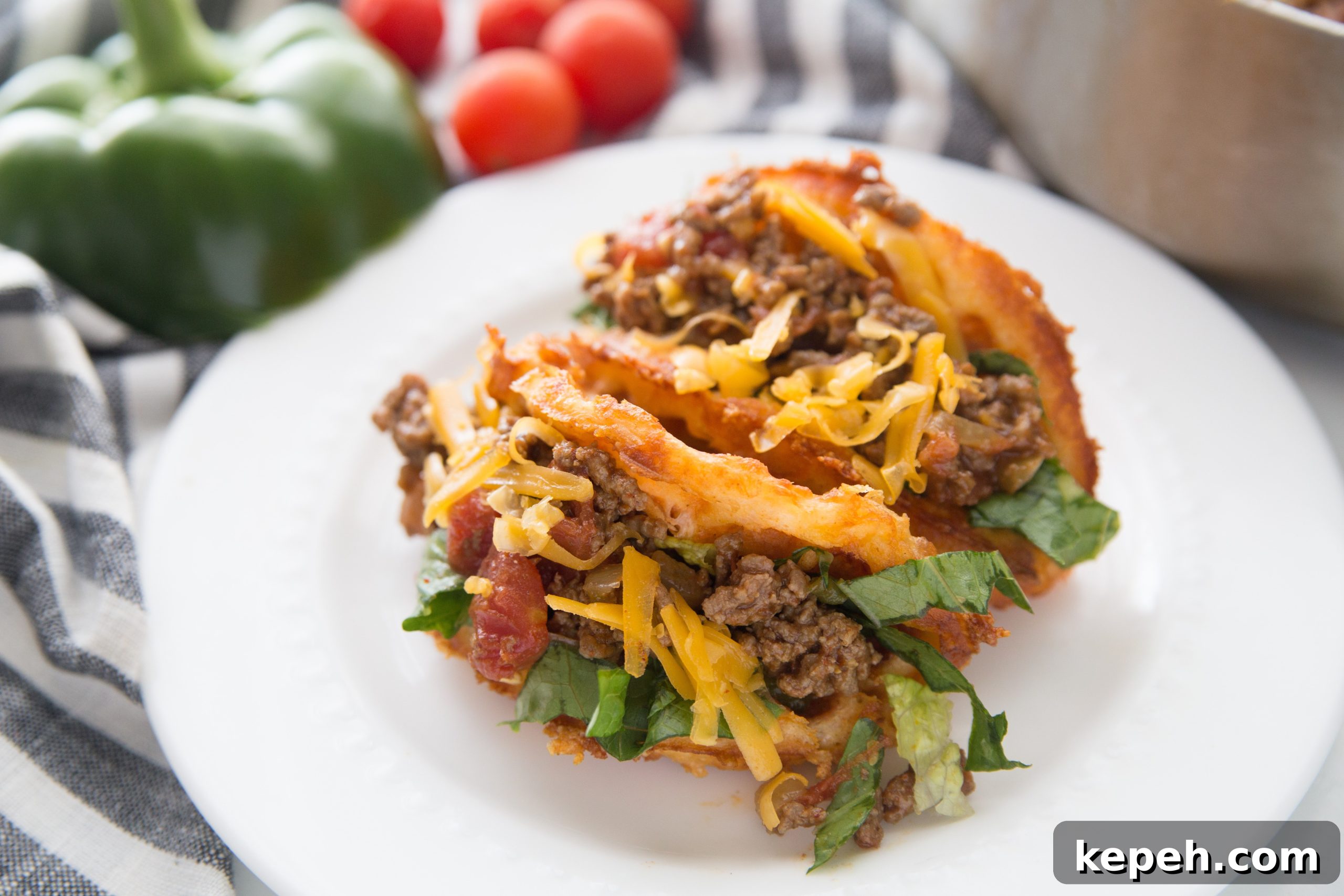 crispy keto taco chaffles filled with ground meat and cheese on a white plate