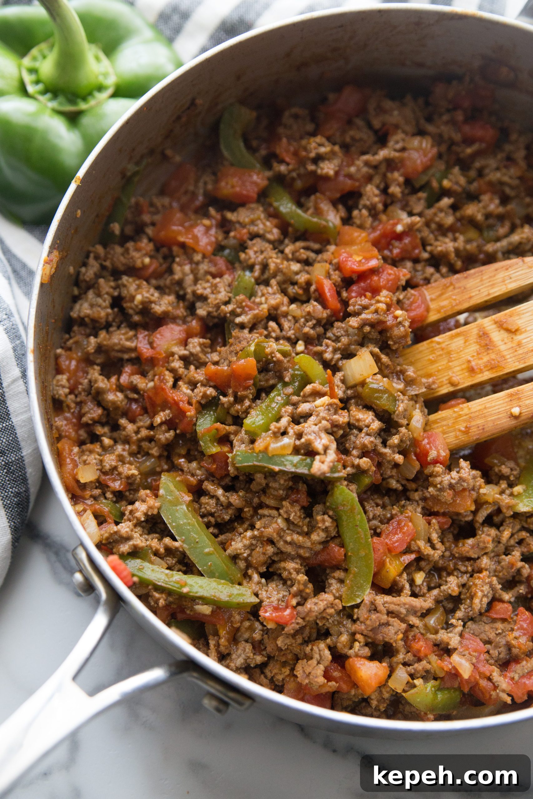 taco seasoned ground beef with peppers in a skillet