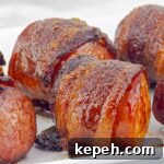 Bourbon Brown Sugar Bacon-Wrapped Sausages Recipe 9 square photo of a bacon wrapped sausage on white tray