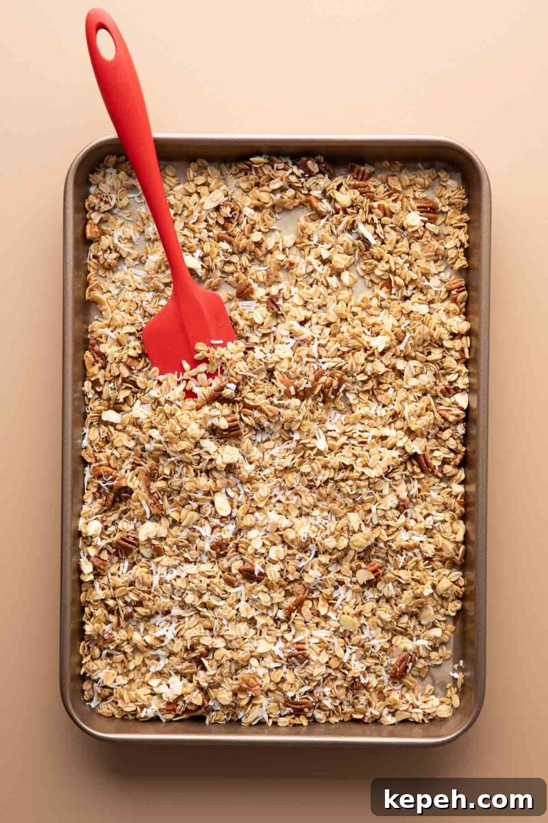 Crunchy Coconut Granola Recipe for Homemade Morning Boost 4 mixing coconut into granola on sheet pan halfway through cooking