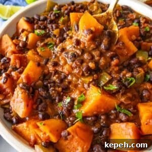 Easy one pot black bean chili in a bowl topped fresh cilantro and lime.