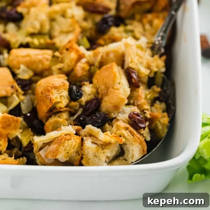 The corner of Italian bread stuffing in a white casserole dish with a spoon in it.