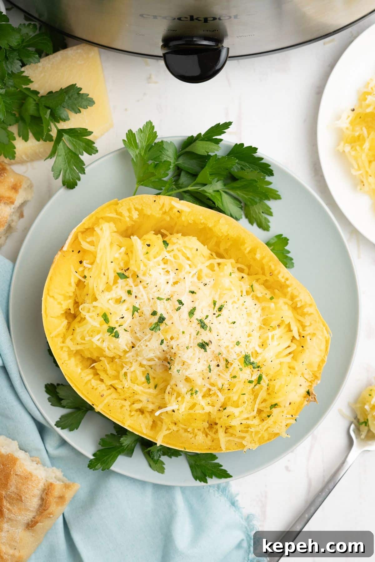 Slow cooker spaghetti squash served up on a blue plate with some parsley for garnish.