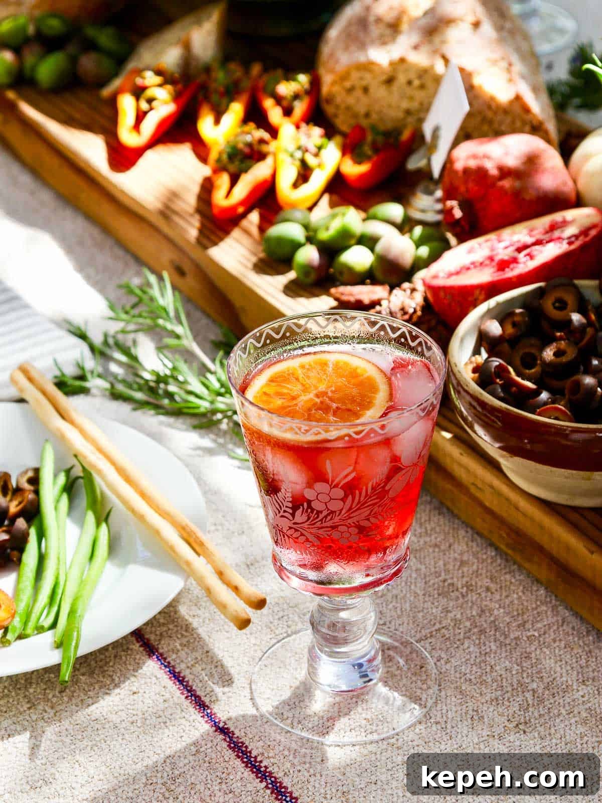 A red hibiscus cocktail in a decorative glass