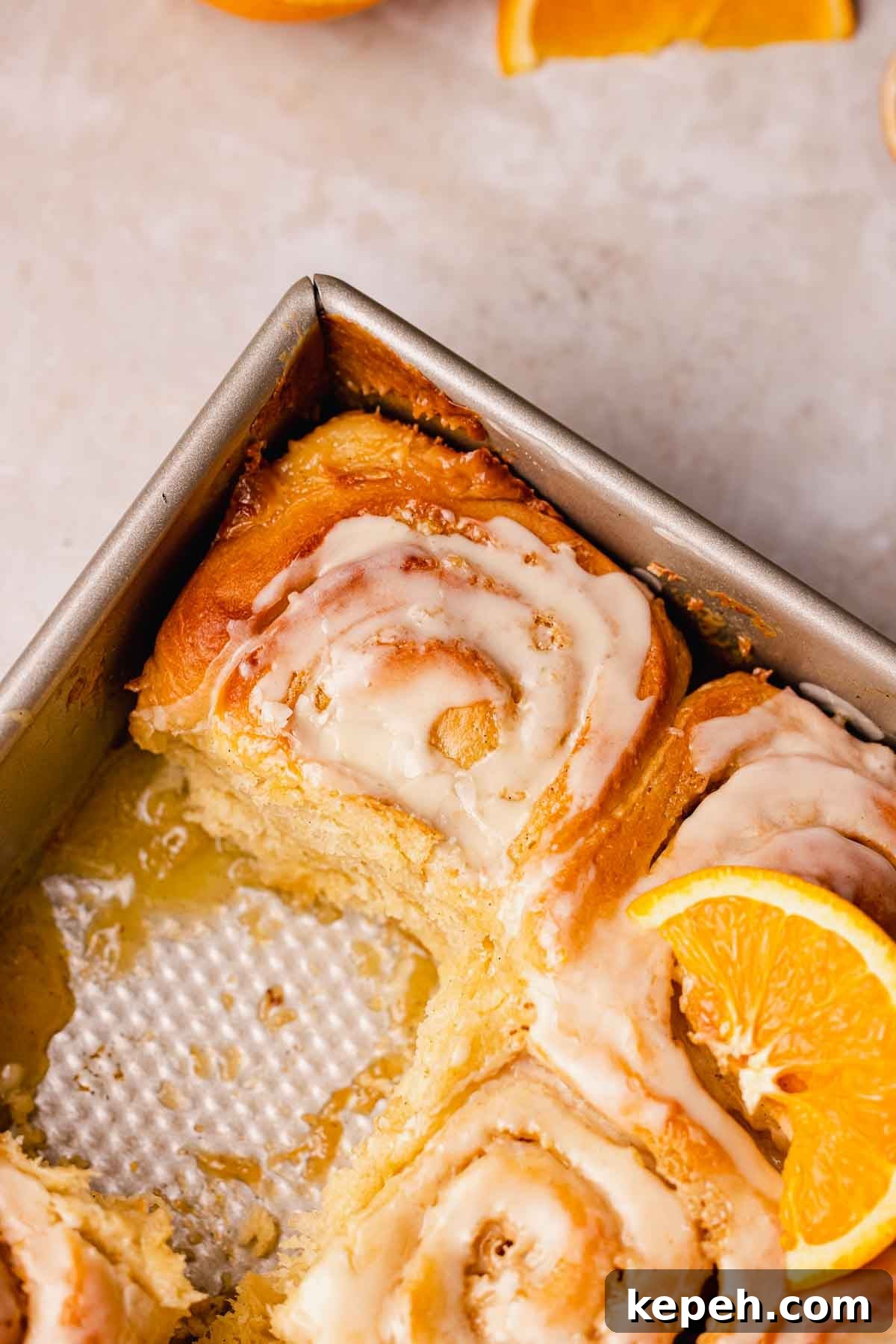 tray of orange cinnamon rolls with 1 missing