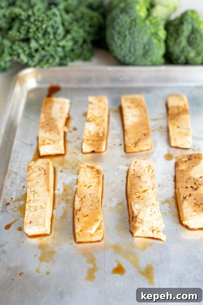 Crispy Tofu and Broccoli Rice Bowl with Sesame-Ginger Sauce 6 Slabs of marinated tofu on a baking tray.