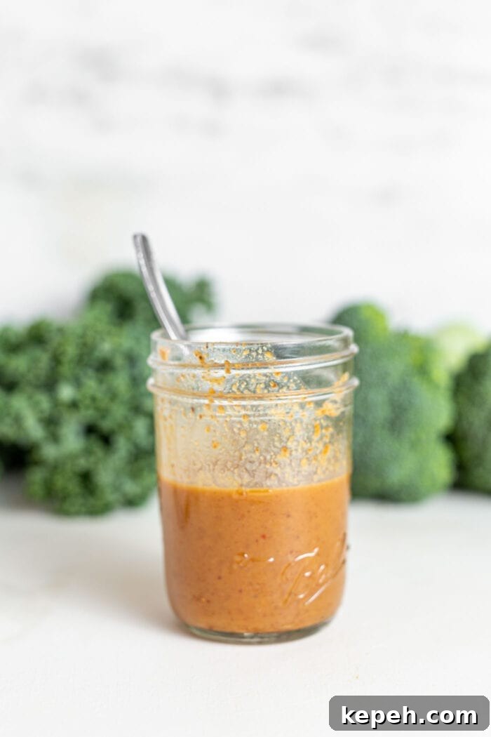 Crispy Tofu and Broccoli Rice Bowl with Sesame-Ginger Sauce 7 Creamy almond sauce in a jar with a spoon.