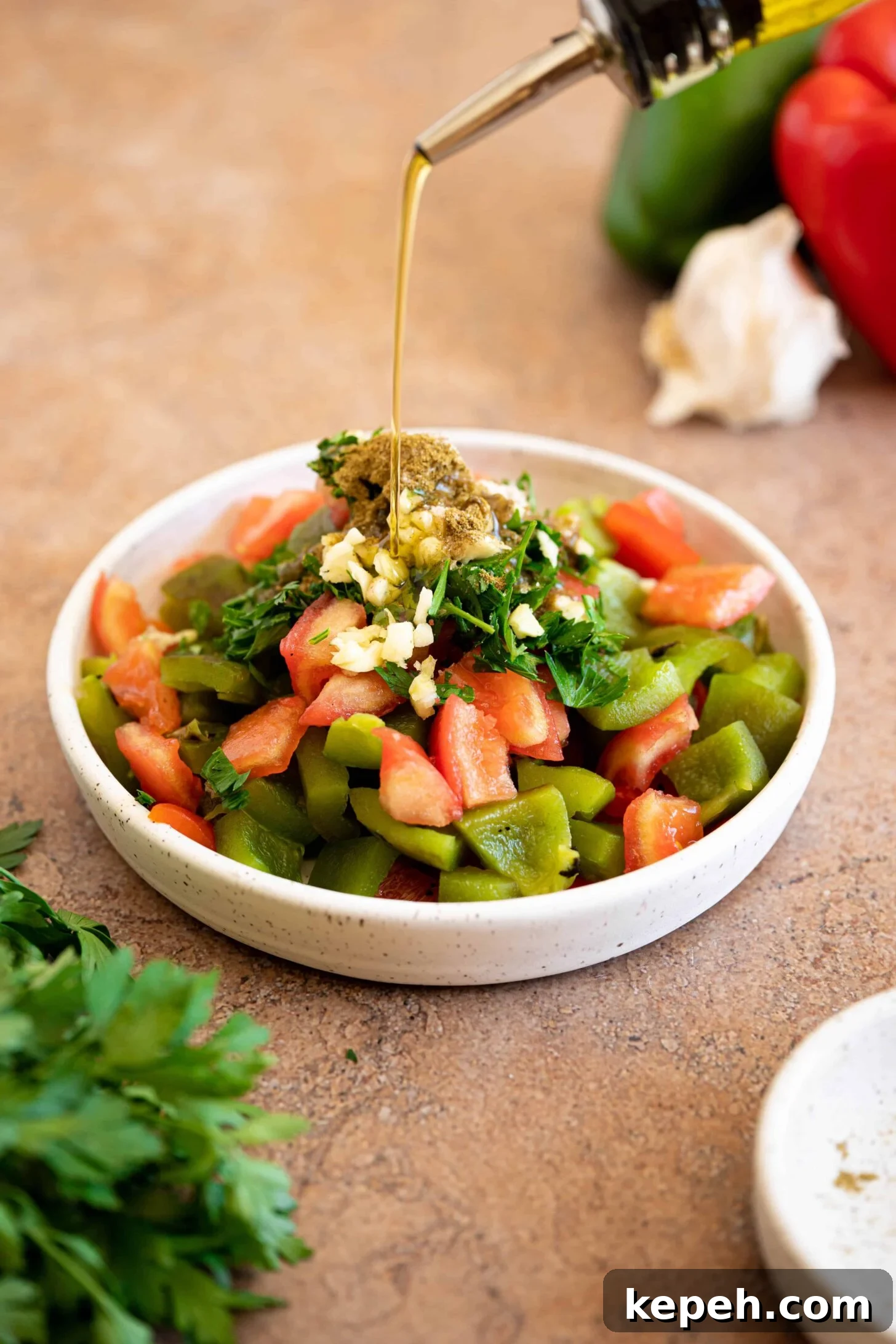 Moroccan Roasted Pepper Salad Recipe with Garlic and Herbs 5 olive oil drizzling over a bowl of roasted pepper salad