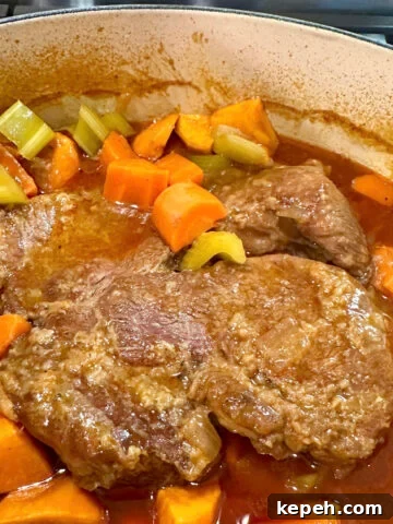 A Dutch oven of tender pot roast with vegetables.