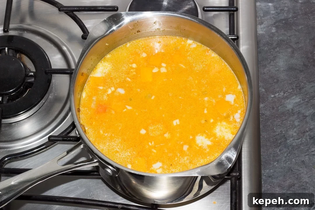 Curried Coconut Lentil Soup with Warm Aromatic Spices 9 curried coconut lentil soup simmering in a large pot on the hob