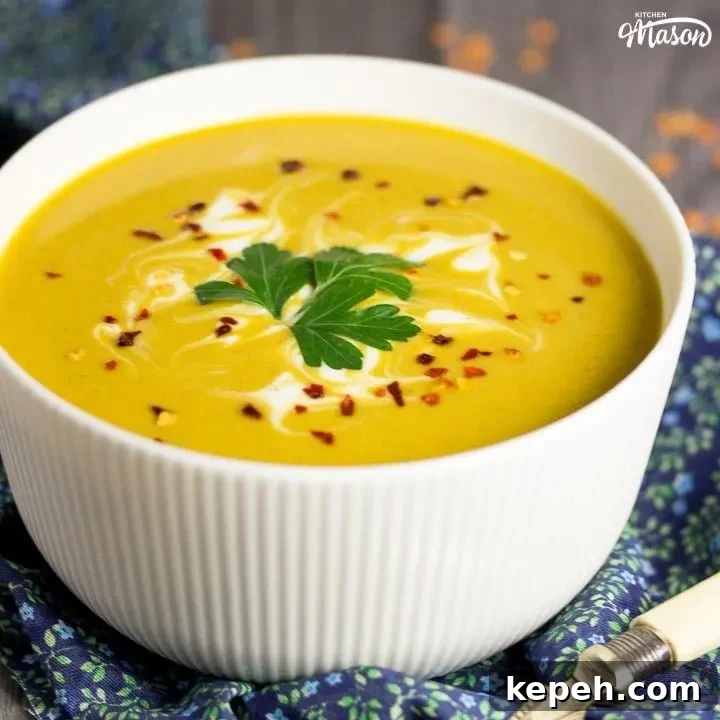 curried coconut lentil soup in a bowl with parsley and chilli flakes on top