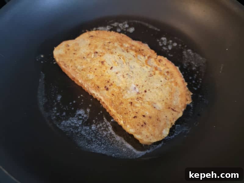 Eggnog French Toast Recipe with Video Tutorial 7 Eggnog French Toast cooking in a pan