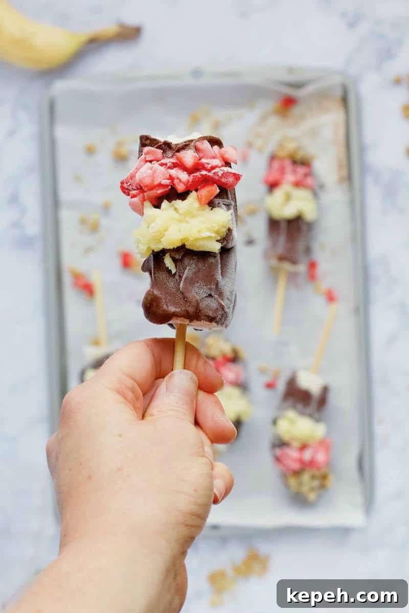 6-Ingredient Frozen Banana Split Popsicles for Summer Treats 2 Hand holding Frozen Banana Split Pop