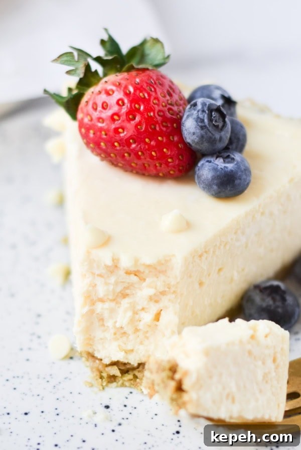 Strawberry Cheesecake Bar Recipe: Creamy No-Bake Dessert Bars 11 A white chocolate cheesecake slice with berries on top.