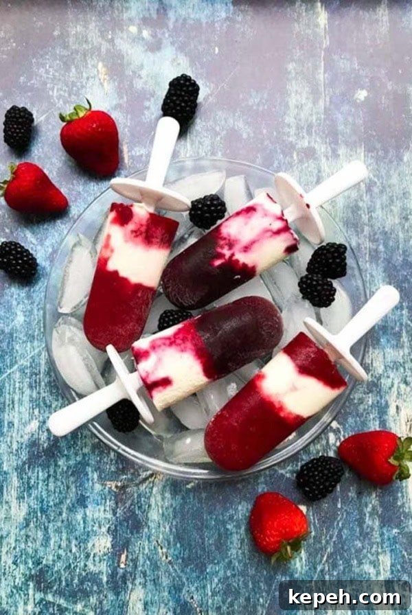 Strawberry Cheesecake Bar Recipe: Creamy No-Bake Dessert Bars 14 Berry Cheesecake popsicles stacked on a bowl of ice