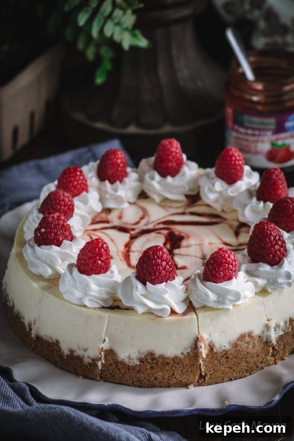 This keto cheesecake with raspberry swirl is delicious and perfect for a low carb and sugar free diet. No-added sugar strawberry/raspberry jam by Sukrin makes the perfect swirl. #ad