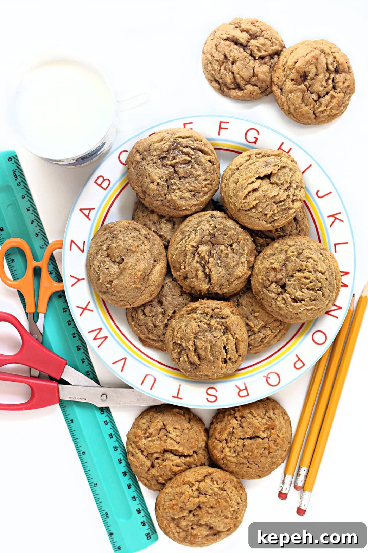 Peanut Butter and Jelly Cookie Recipe: Soft, Jam-Filled Treats 2 Golden brown peanut butter and jelly cookies on a plate with the alphabet around the rim.