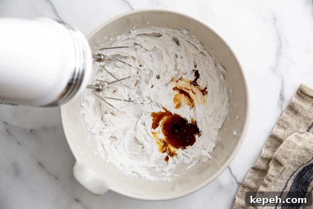 Process shot showing how to beat coconut cream with vanilla and maple syrup for the vegan whipped cream topping.
