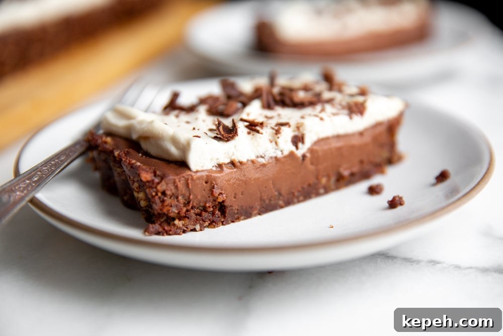 A slice of no bake chocolate tart on a plate with a fork.