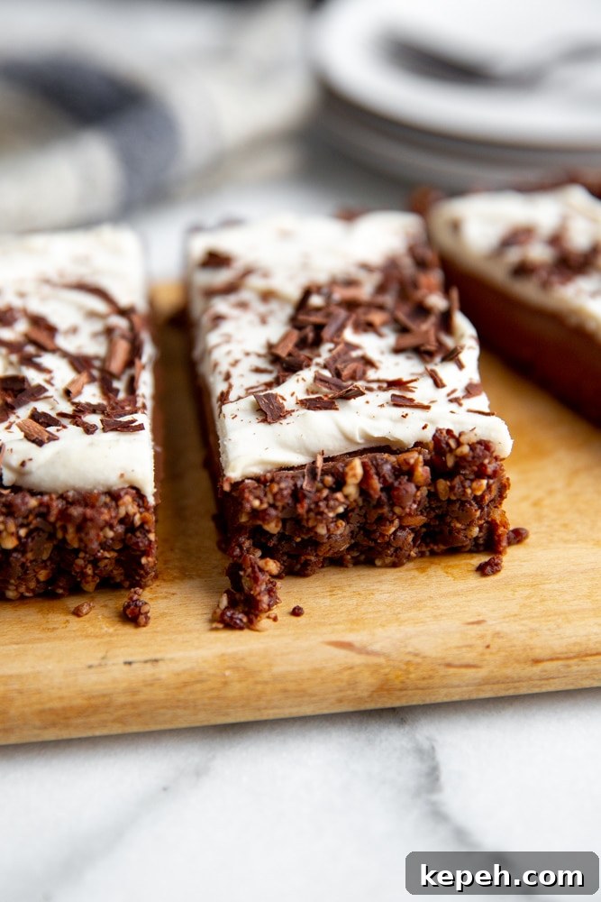 Close up of a slice of chocolate tart, showing the date pecan crust.