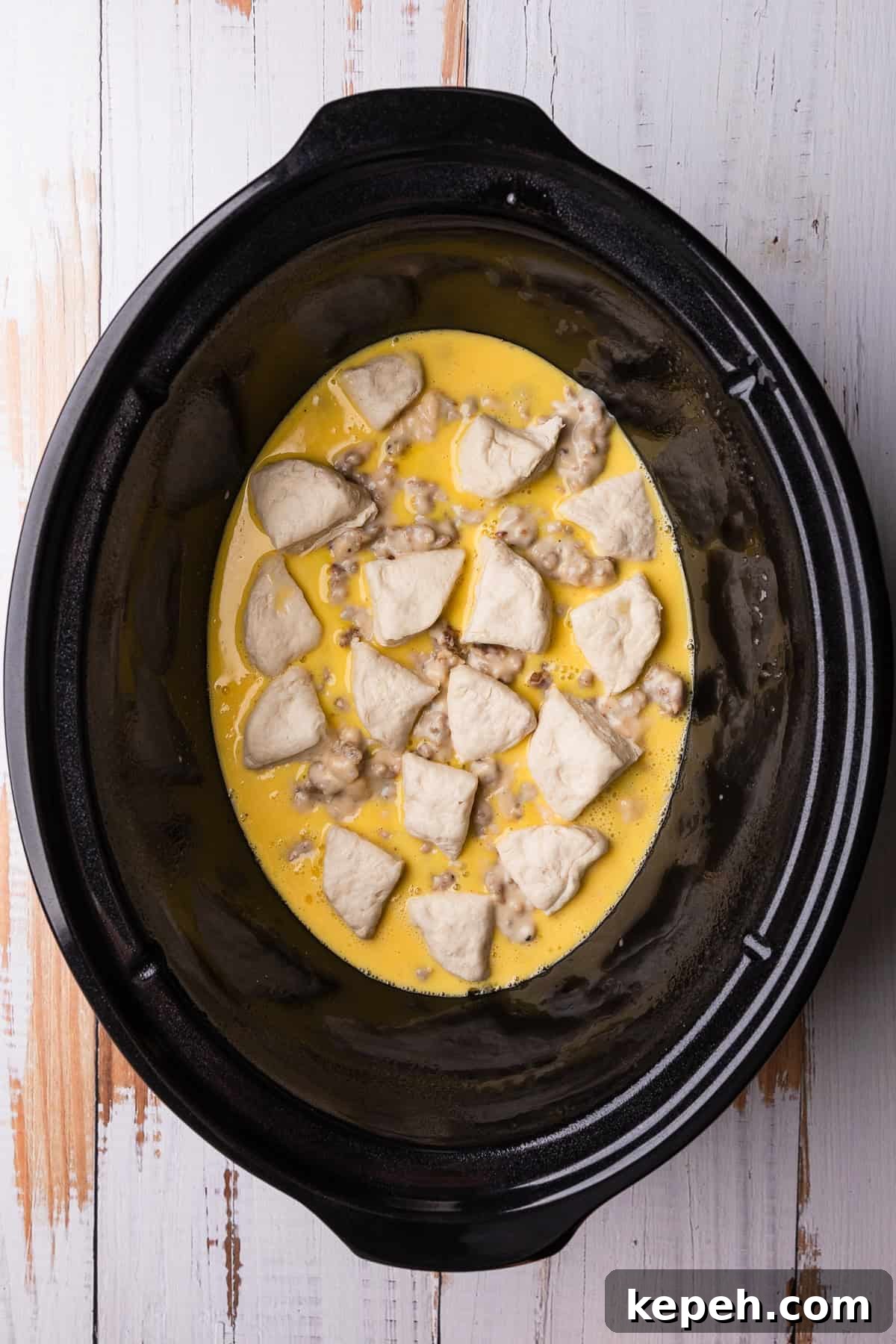 Crockpot Biscuits and Sausage Gravy Casserole 10 Adding the second layer of biscuits.