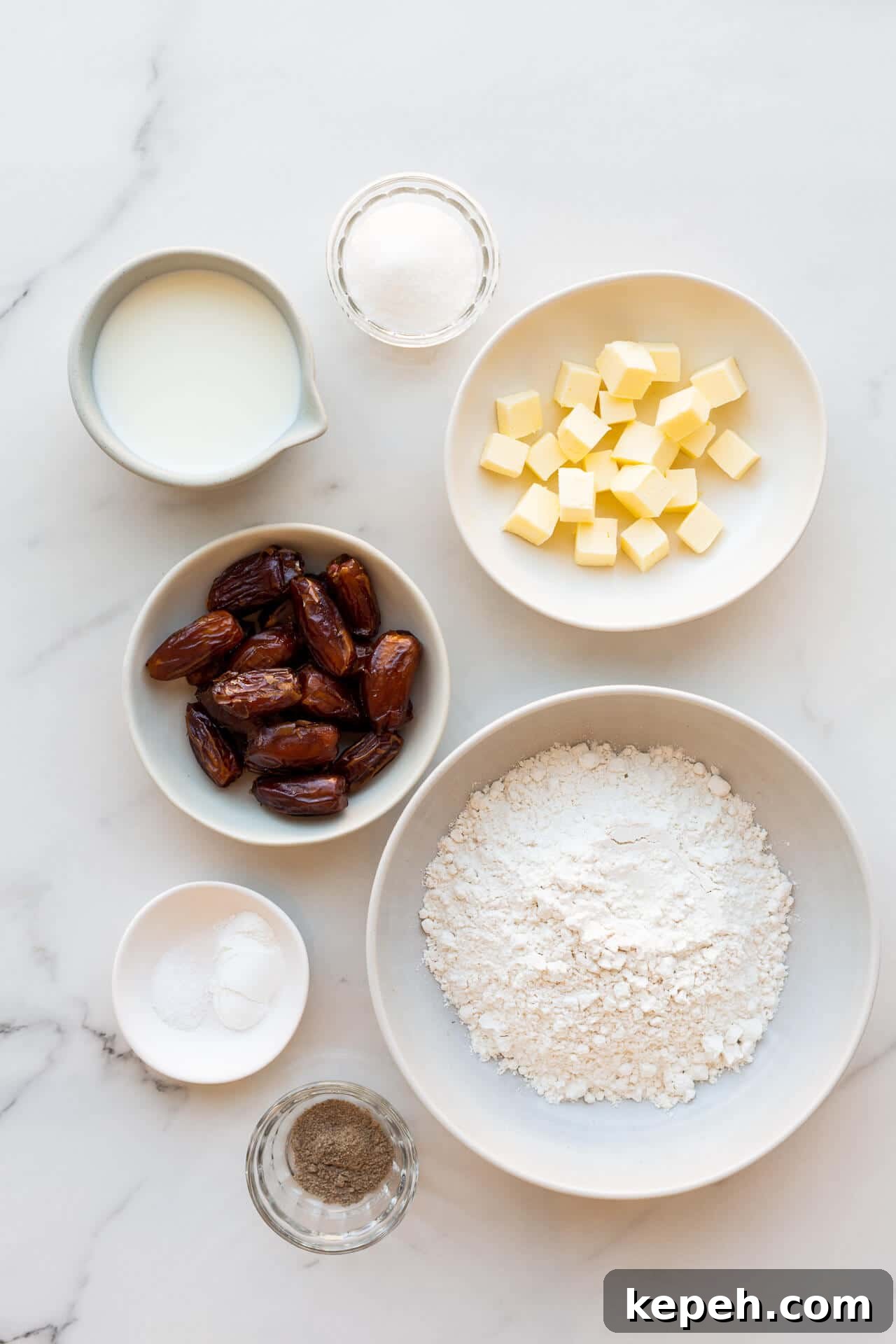 Chewy Date Scones with Honey Glaze 3 Ingredients to make date scones included cubed butter, salt, baking powder, cream, chopped pitted dates, sugar, flour, and ground cardamom all in bowls for mise-en-place