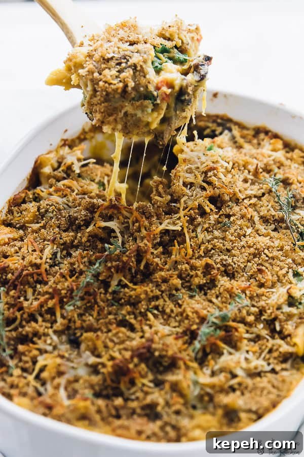 A spoon scooping out some butternut squash casserole from a baking dish.