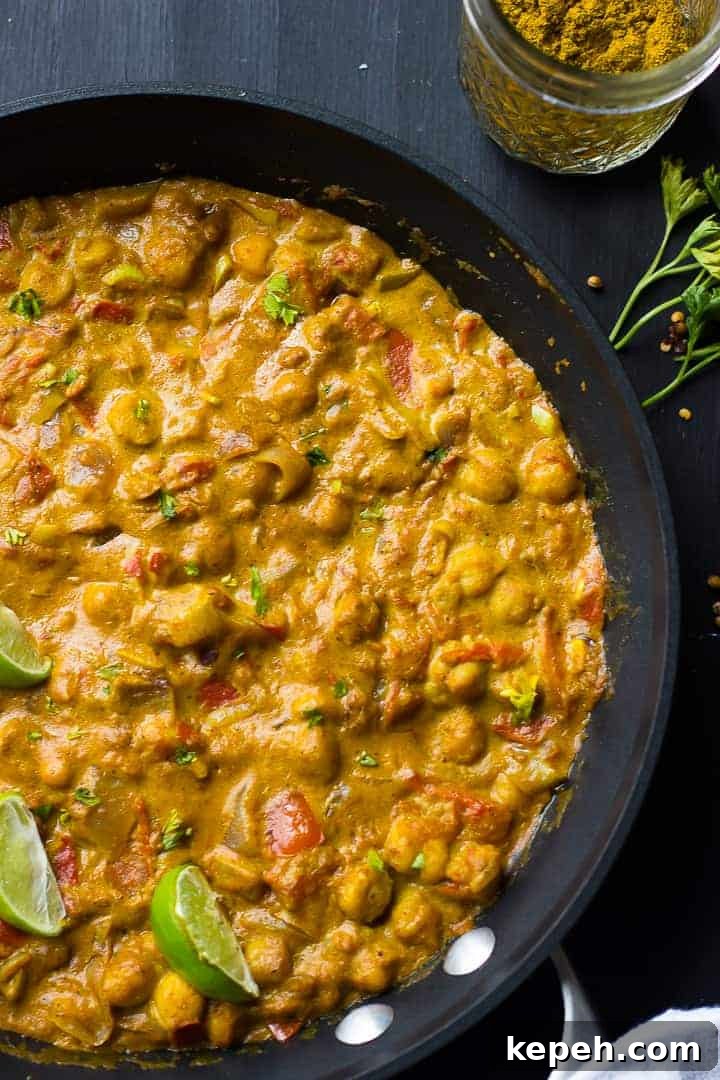 Overhead view of coconut chickpea curry in a black skillet. 