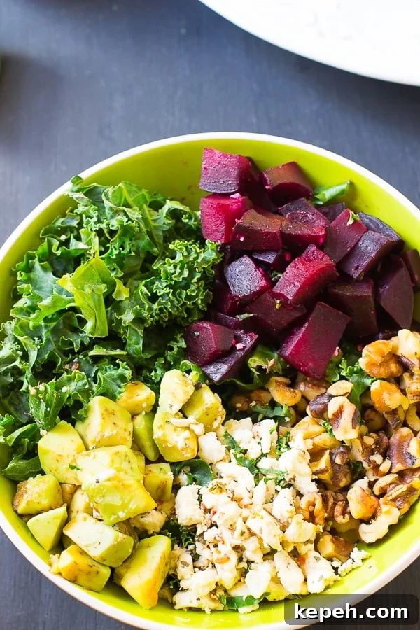 Overhead view of roasted beet salad in a green bowl. 
