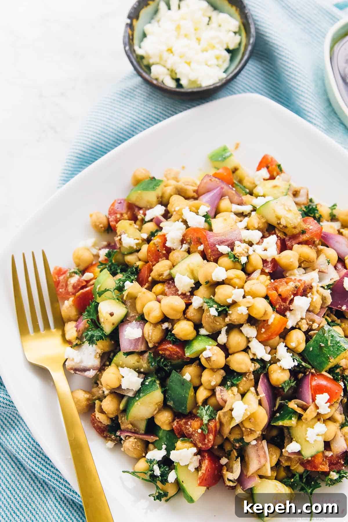 Mediterranean chickpea salad with a gold fork on the side. 