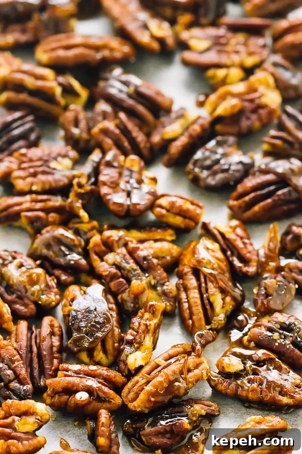Close up of candied pecans on a baking sheet. 