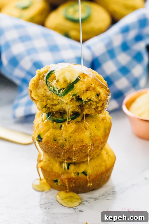 A stack of cornbread muffins being drizzled with syrup. 