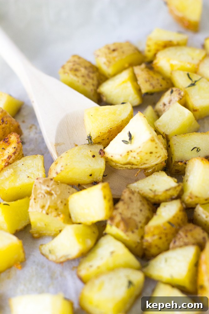 Garlic butter potatoes being stirred with a wood spoon. 