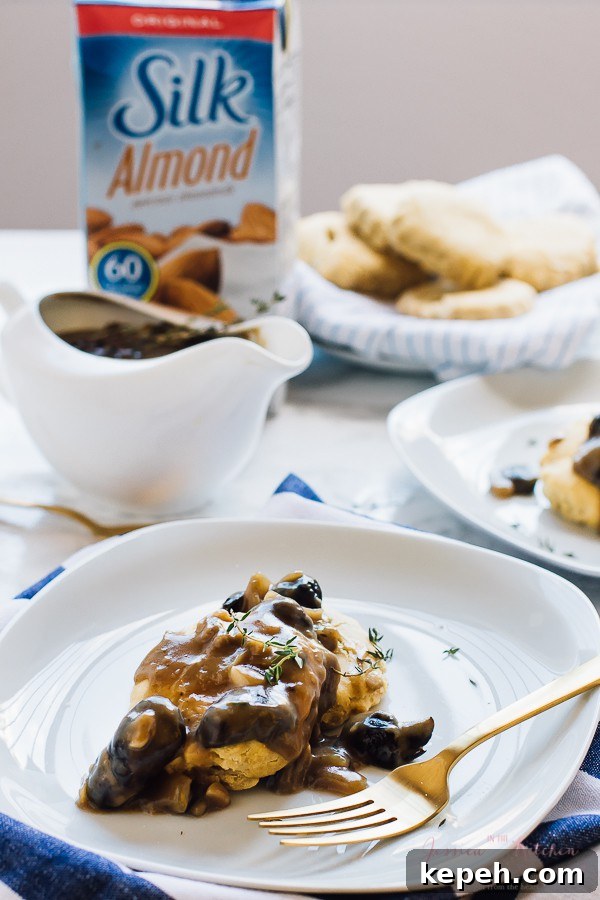 Mushroom gravy over a biscuit with a gold fork on the side. 