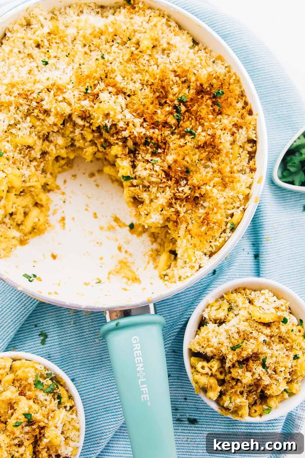 Baked vegan mac & cheese in a skillet and in bowls. 