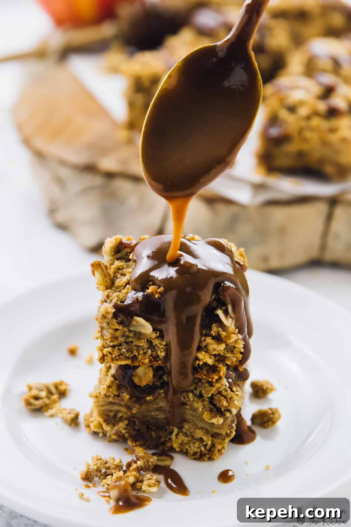 A stack of apple pie bars drizzled in caramel sauce. 
