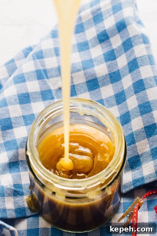 Vegan caramel sauce being poured into a glass jar. 