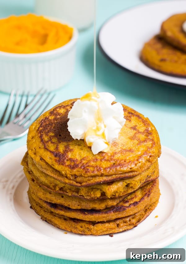 A stack of pumpkin pancakes, drizzled with syrup.